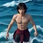 主编 Alex 阿磊的工作照，戴着耳机坐在双屏工作站前专注审核男同网站内容导航条目，表情认真专业